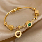 Goudkleurige bedelbangle met groene steenbedel