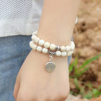 Witte kralenarmband met levensboom-bedel