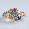 Ring met cluster van veelkleurige kristallen en goudkleurige crossover-band