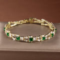 Tennisarmband met schakels en groene stenen in goudkleur