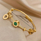 Goudkleurige bedelbangle met groene steenbedel