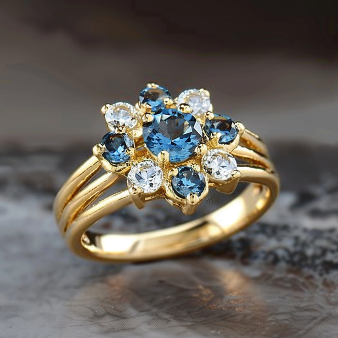 Goudkleurige ring met blauwe bloem van zirkonia