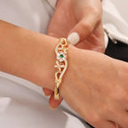 Goudkleurige bangle met middensteen