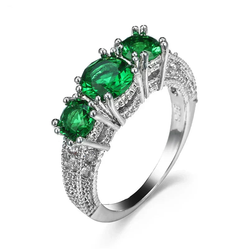 Zilverkleurige ring met drie groene kristallen en gegraveerde band