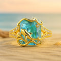 Goudkleurige dolfijnring met blauw kristal