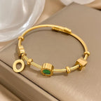 Goudkleurige bedelbangle met groene steenbedel