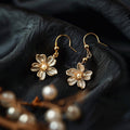 Goudkleurige bloemoorhangers met parels