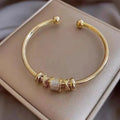 Adjustable Gold-Tone Open Cuff Bracelet with Bead Charms