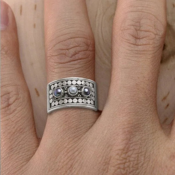 Geometrische gesneden ring met drie stenen en parel