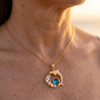 Goudkleurige dolfijnketting met blauw kristal