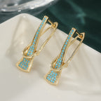 Goudkleurige paperclip-oorhangers met synthetisch turkoois