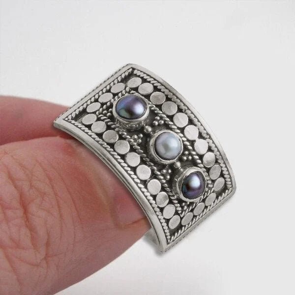 Geometrische gesneden ring met drie stenen en parel