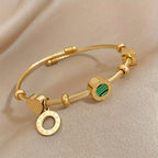 Goudkleurige bedelbangle met groene steenbedel