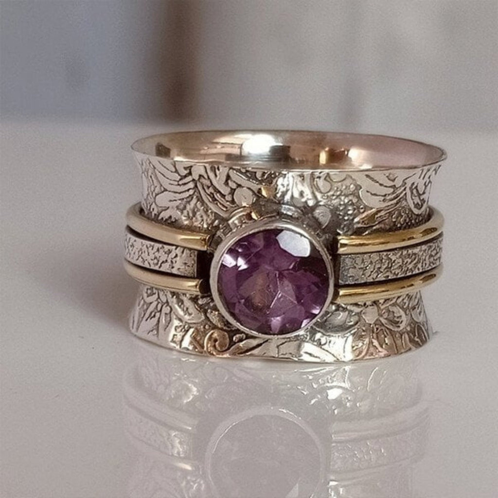 Gelaagde spinnerring met rond paars kristal