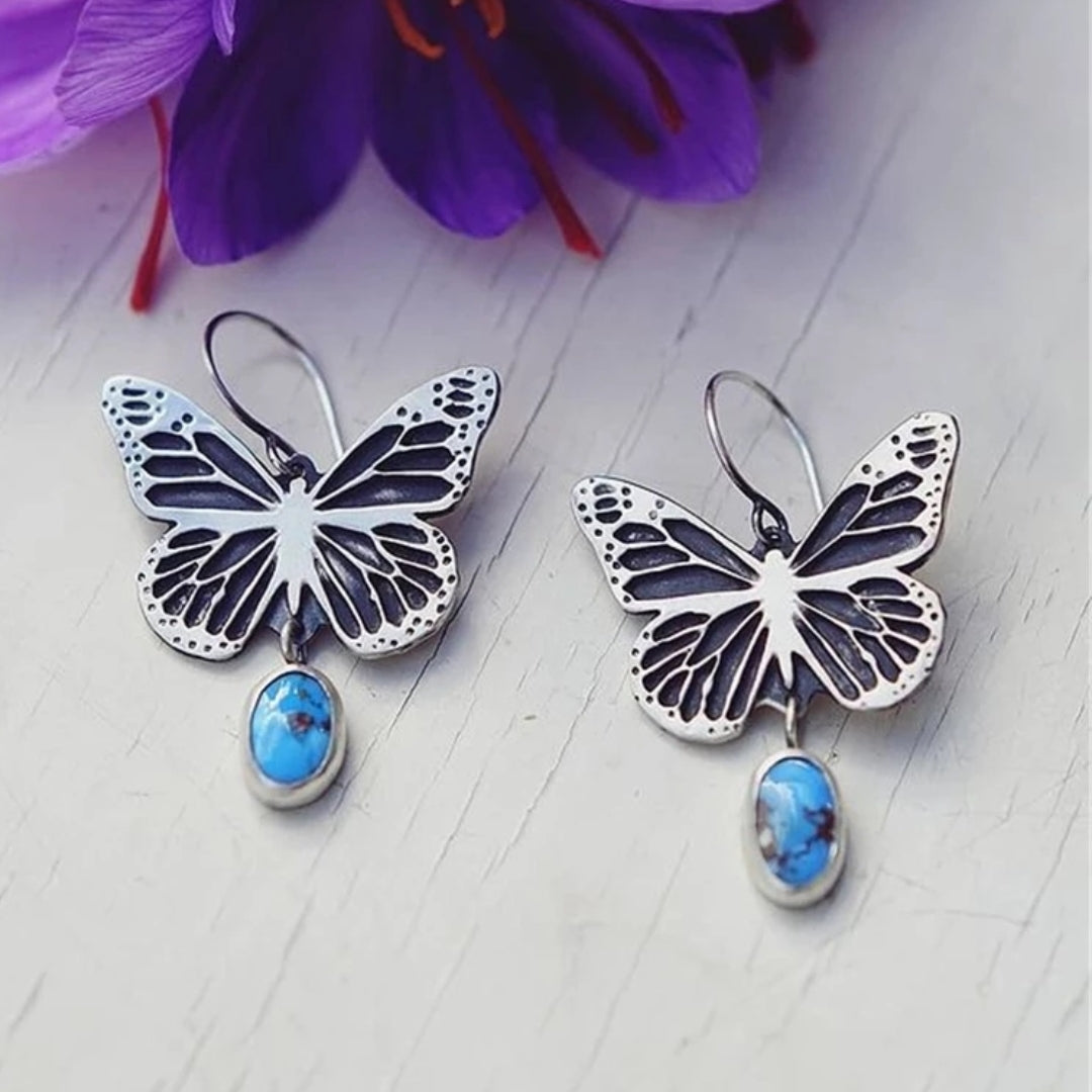 Zilverkleurige oorbellen met vlinder en blauwe steen in vintagestijl