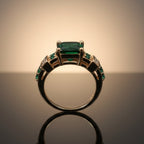 Brede goudkleurige ring met groot groen kristal en railzetting-accenten