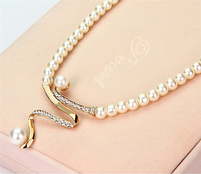 Set van parelketting en oorhangers met goudkleurige golf