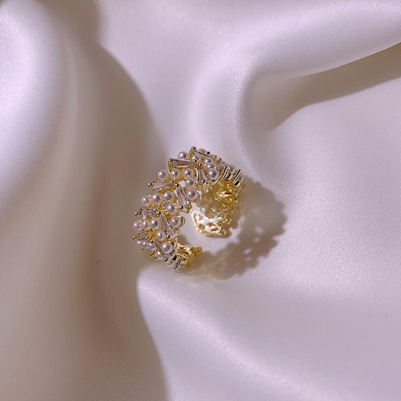 Open goudkleurige ring met cluster van kristal en parellook