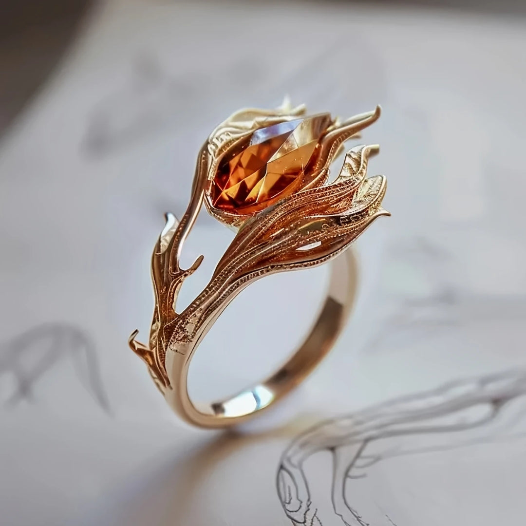 Goudkleurige ring met oranje kristal en exotisch ontwerp
