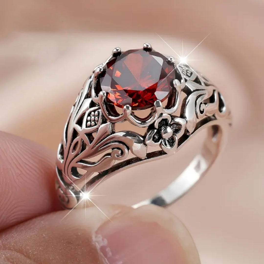 Holle zilverkleurige ring met rode zirkonia