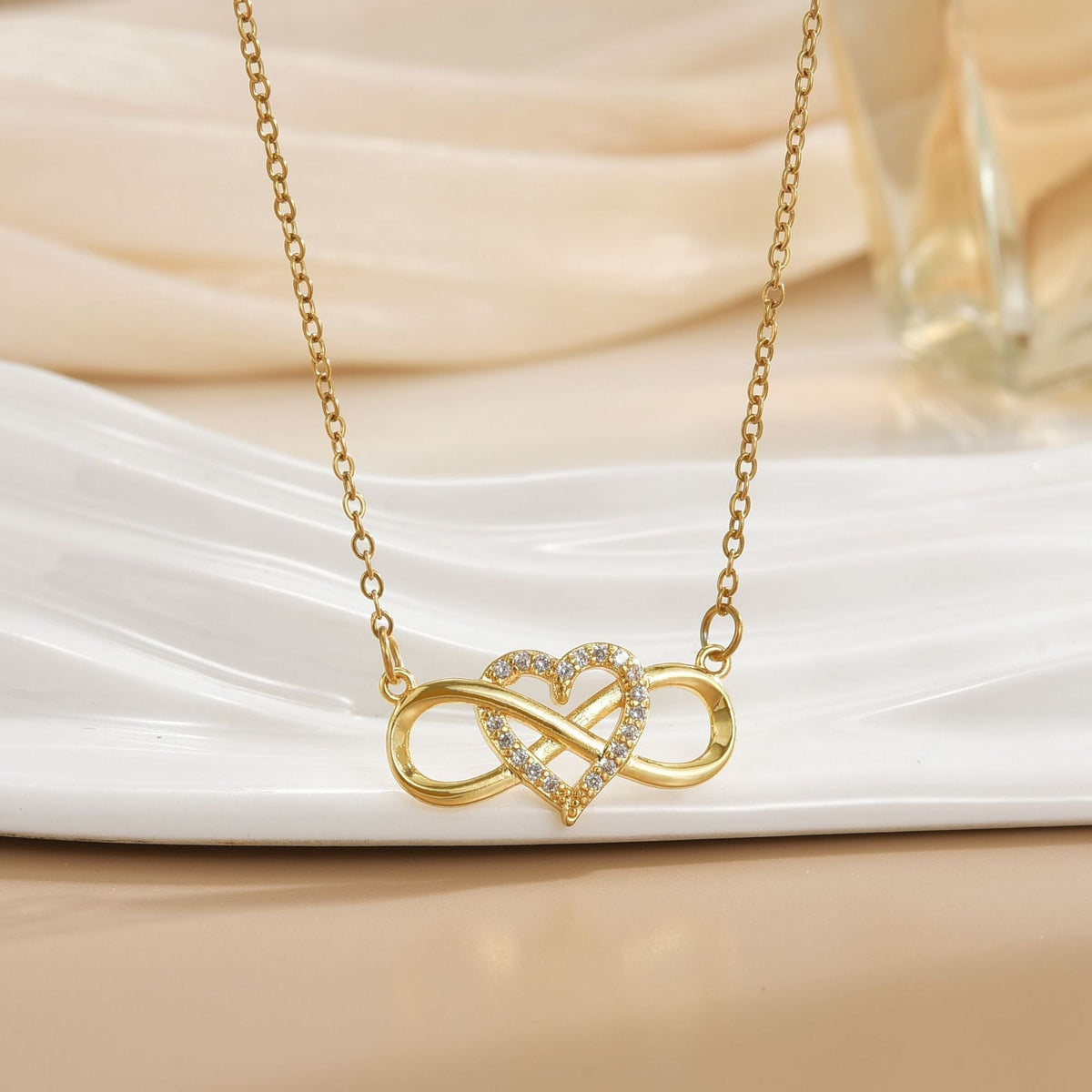 Goudkleurige ketting met liefdesknoop en oneindigheid