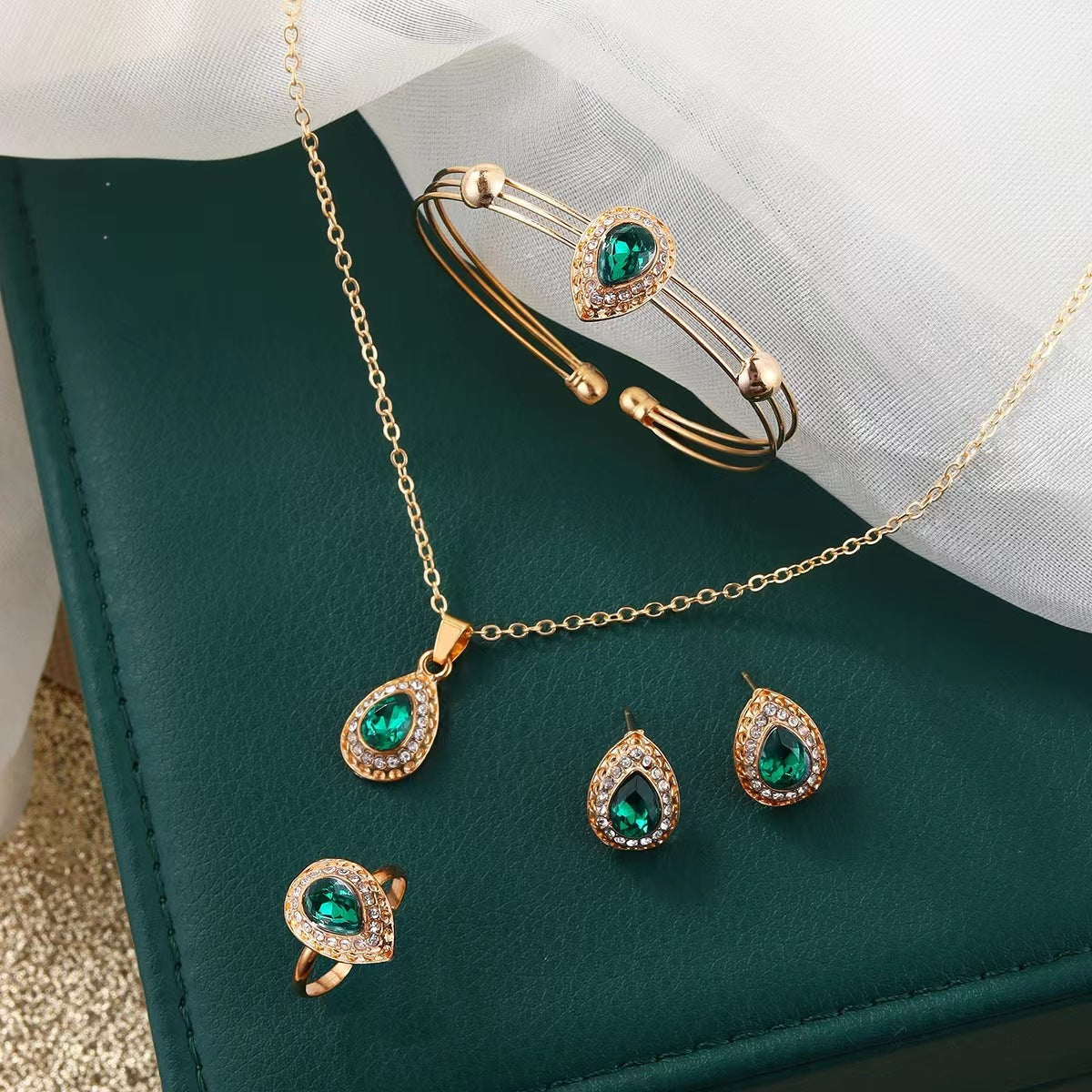 Set met ketting, oorbellen, armband en ring met groene druppel