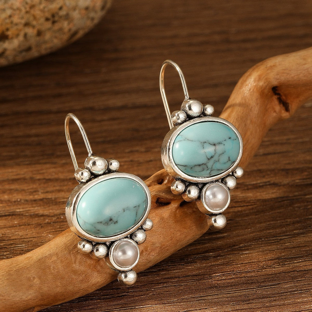 Oorhangers met ovale turquoise steen en pareldetail