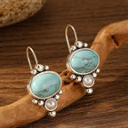 Oorhangers met ovale turquoise steen en pareldetail