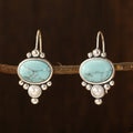 Oorhangers met ovale turquoise steen en pareldetail