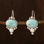 Oorhangers met ovale turquoise steen en pareldetail