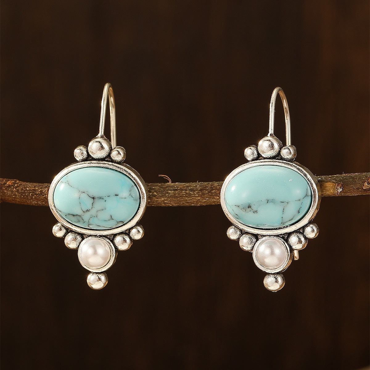 Oorhangers met ovale turquoise steen en pareldetail