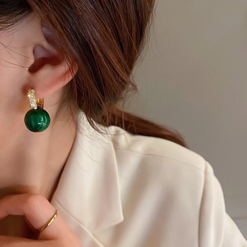 Oorbellen met groene jadelook-bol en kristallen knopje