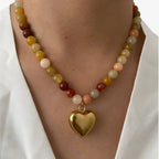 Kleurrijke kralenketting met goudkleurige hartbedel