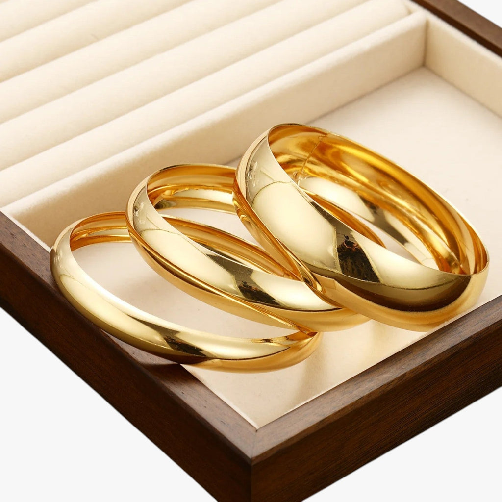 Set van drie brede bangles, goudkleurige afwerking