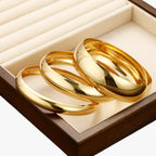 Set van drie brede bangles, goudkleurige afwerking