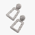 Sculpturale geometrische oorhangers in mat metaal