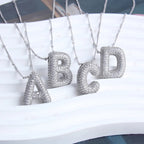 Ketting met bubbelletter-initiaal in twee metaalkleuren