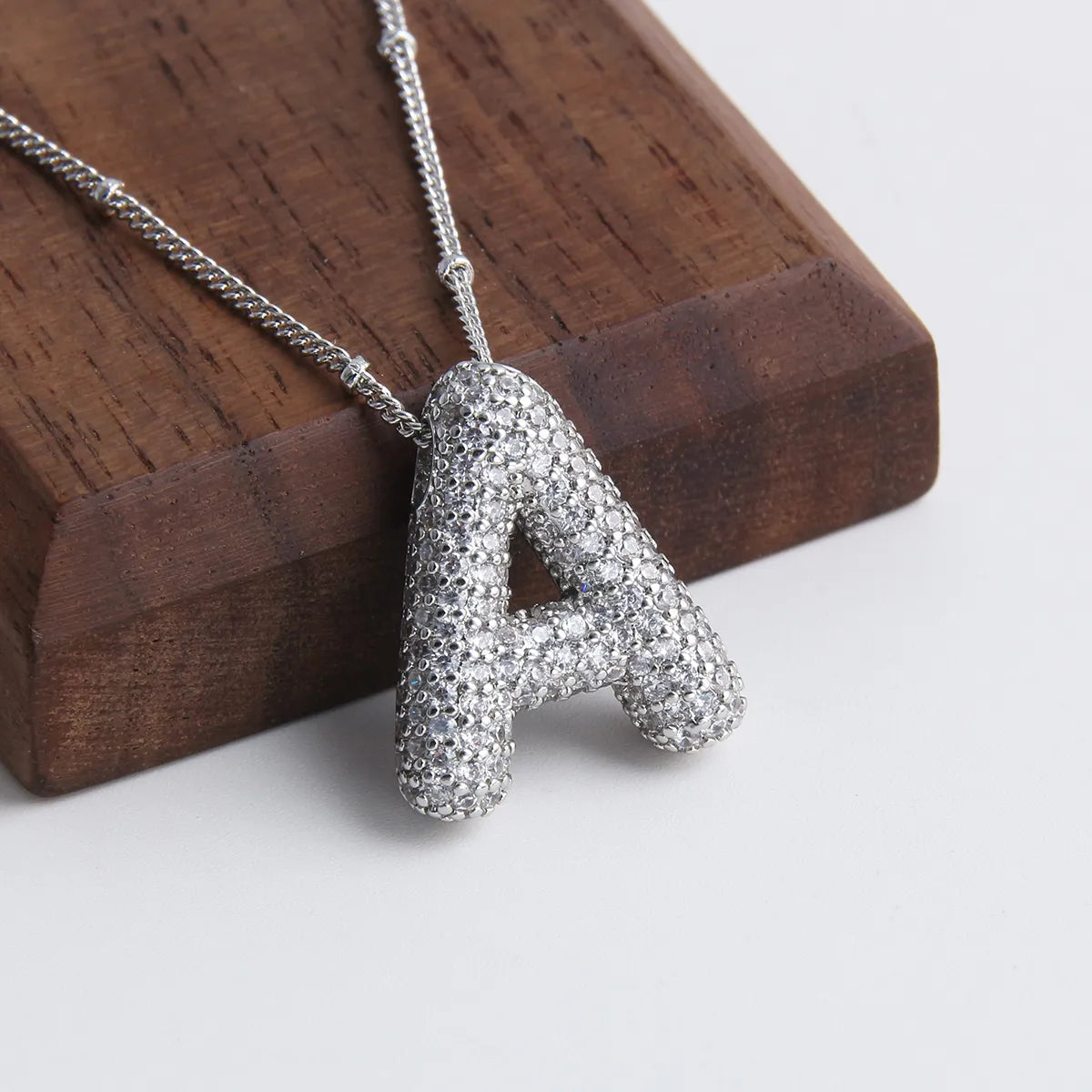 Ketting met bubbelletter-initiaal in twee metaalkleuren