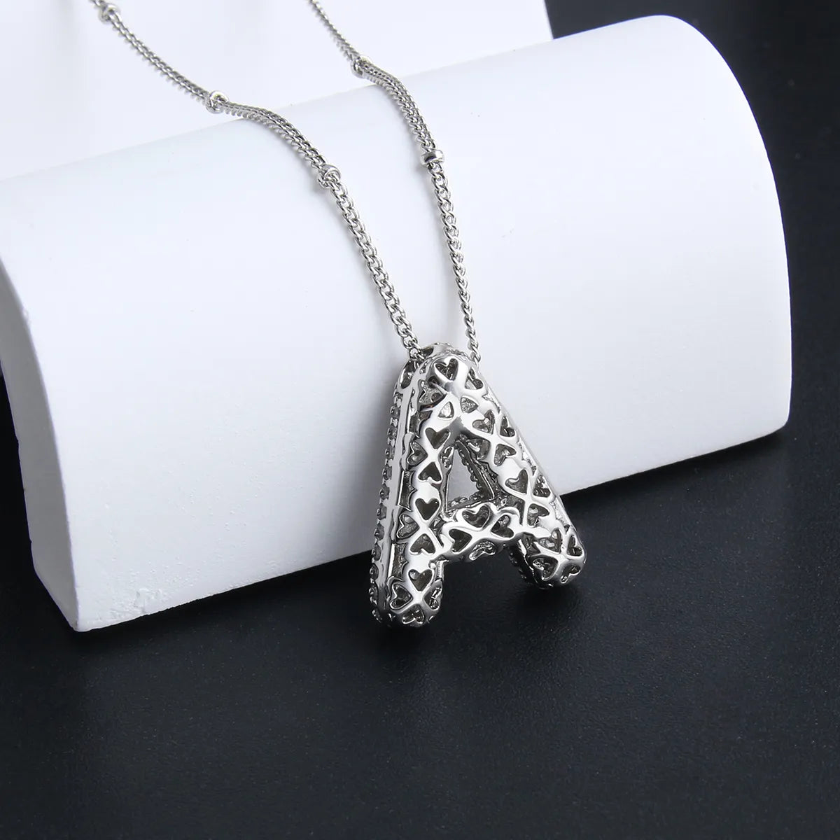 Ketting met bubbelletter-initiaal in twee metaalkleuren