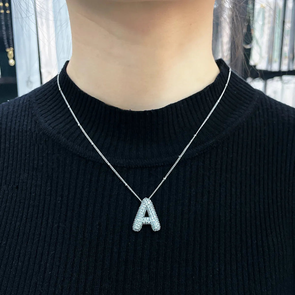 Ketting met bubbelletter-initiaal in twee metaalkleuren