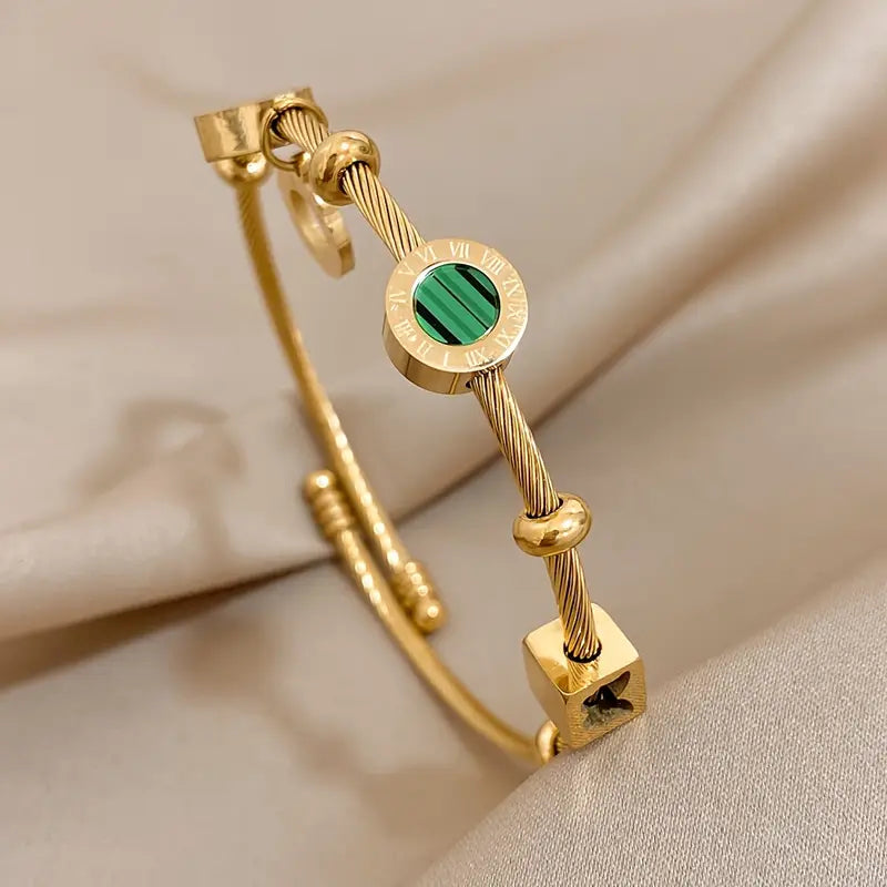 Goudkleurige bedelbangle met groene steenbedel