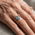 Goudkleurige ring met oceaangolf en blauw kristal