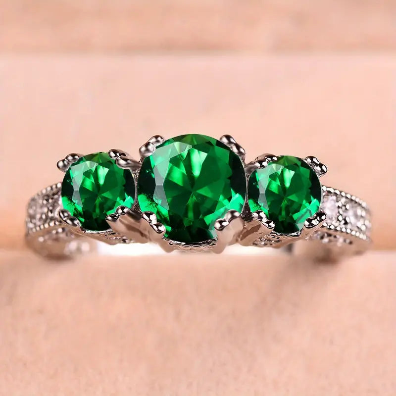 Zilverkleurige ring met drie groene kristallen en gegraveerde band