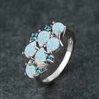 Klassieke clusterring met waterdruppels in opaallook in drie kleuren