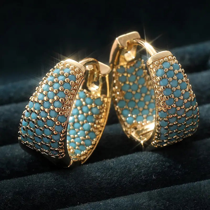 Goudkleurige oorringen met turquoise kralen
