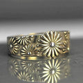 Goudkleurige bandring met madeliefjespatroon