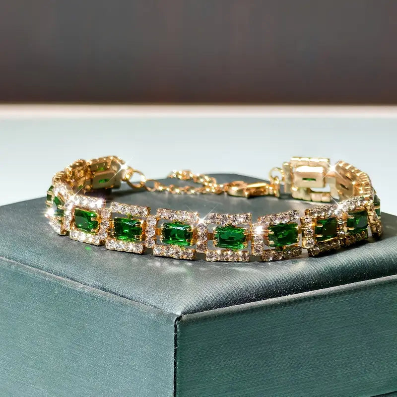 Smaragdgroene stenen schakelarmband in goudkleur