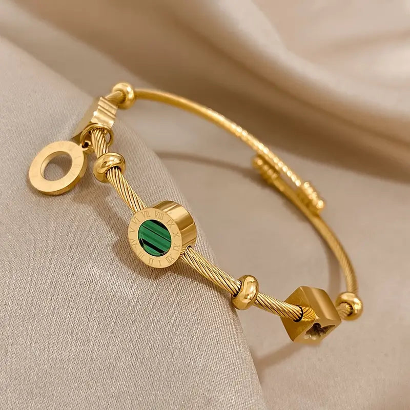 Goudkleurige bedelbangle met groene steenbedel