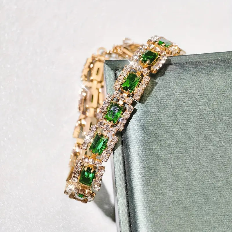 Smaragdgroene stenen schakelarmband in goudkleur
