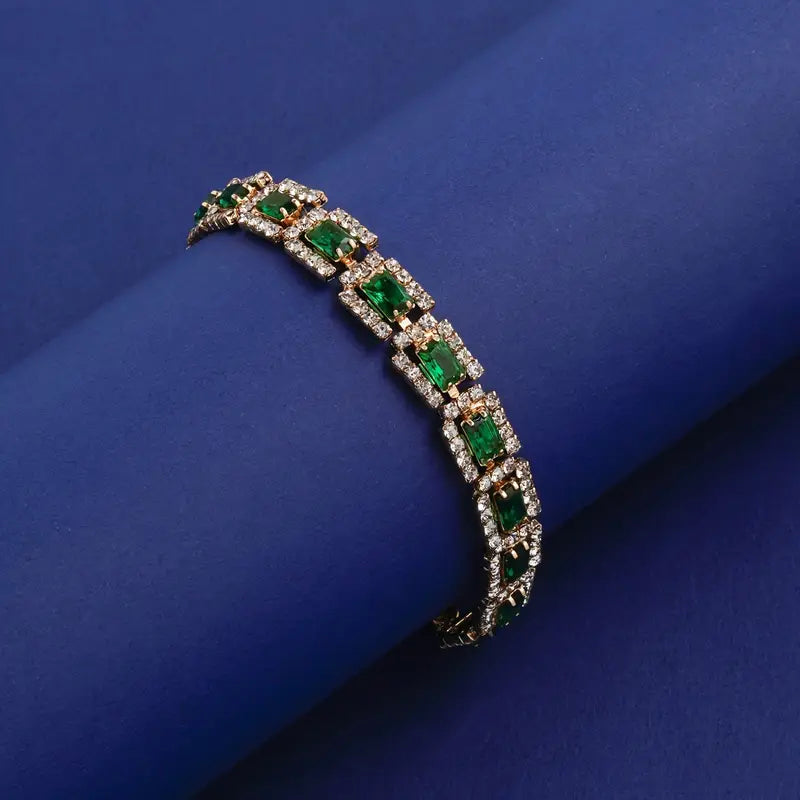 Smaragdgroene stenen schakelarmband in goudkleur